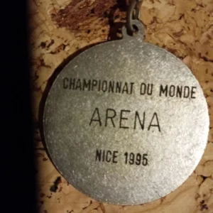 Médaille gravée "Championnat du Monde Arena, Nice 1995", symbolisant une étape marquante dans le parcours d'un athlète.
