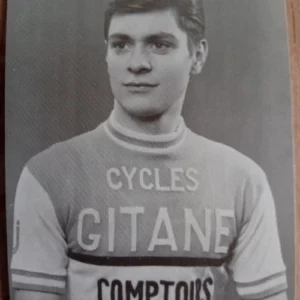 Portrait d'un cycliste portant le maillot officiel de l'équipe "Cycles Gitane Comptoirs", symbole de son parcours sportif.