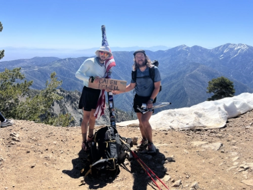 Antoine Clément et un compagnon de trail au sommet d’une montagne sur le Pacific Crest Trail, célébrant leur défi d’ultra-endurance.