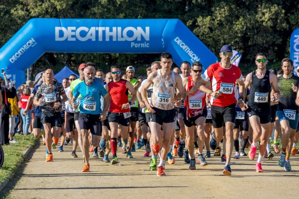 Départ groupé des coureurs au top départ de la Course Nature du Croisic 2024, sous l’arche bleue Decathlon.