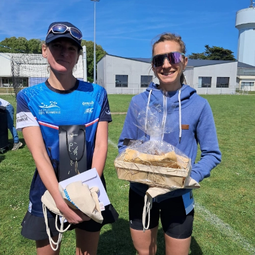 Deux participantes souriantes posent avec leurs récompenses après la course nature de Le Croisic, sous un ciel ensoleillé.
