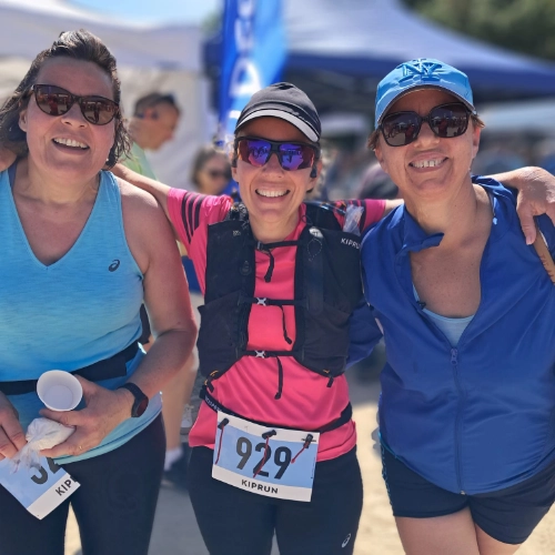 Trois participantes souriantes posent ensemble après la course nature de Le Croisic, vêtues de tenues de sport colorées.