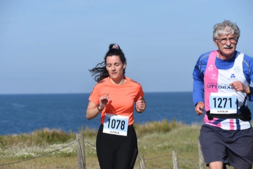 Deux coureurs participent à la course nature de Le Croisic, longeant le littoral sous un ciel bleu.