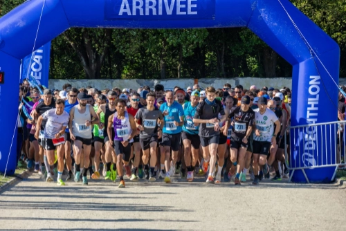 Départ de la course nature de Le Croisic avec un large groupe de coureurs franchissant l’arche de départ sous un ciel dégagé.