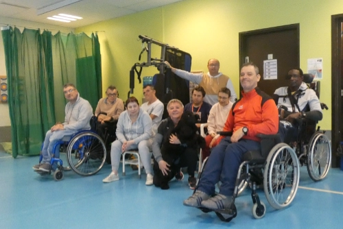 Un groupe mixte de personnes valides et en situation de handicap pose ensemble dans un gymnase au Croisic, illustrant l’esprit d’inclusion handicap sport Le Croisic dans un cadre collectif et bienveillant.