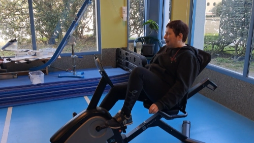 Une femme utilise un appareil de musculation adapté dans une salle au Croisic, illustrant l’inclusion handicap sport Le Croisic à travers la pratique d’une activité physique individualisée.