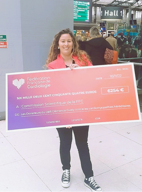 Clémence tient un chèque de 6254 euros remis à la Fédération Française de Cardiologie pour la recherche sur les cardiomyopathies héréditaires.