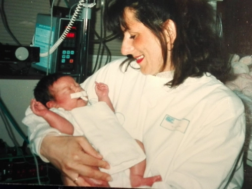 La mère de Clémence tient tendrement sa fille nouveau-née dans un service hospitalier, marquant le début de son parcours face à la cardiomyopathie hypertrophique.
