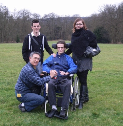 Julien Gloanec en fauteuil roulant entouré de sa famille, illustrant le soutien et la rééducation après une lésion cérébrale.