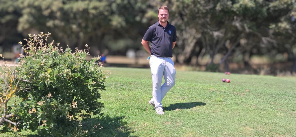 Un homme debout sur un terrain de golf verdoyant au Croisic, illustrant le développement du golf dans cette région.