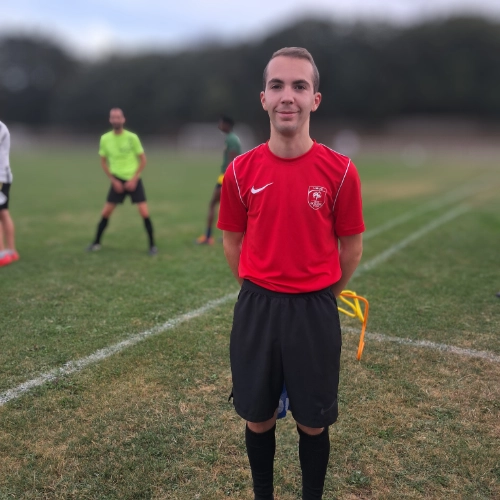 Jeune arbitre du club de football Le Croisic debout sur le terrain avant un match ou un entraînement.