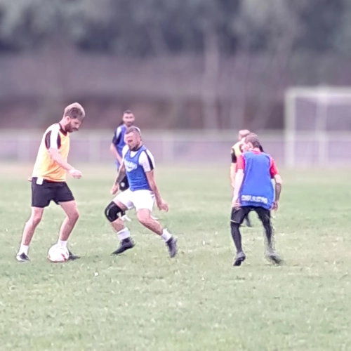 Séance d’entraînement en petit groupe sur le terrain du club de football Le Croisic, avec plusieurs joueurs en action.