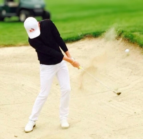 Jeune golfeur en action dans un bunker sur un parcours au Croisic, illustrant le développement du golf local.