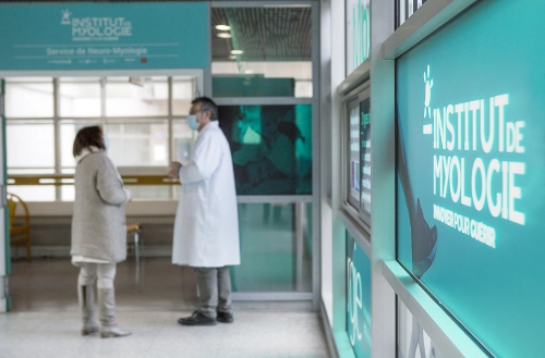 Un médecin en discussion avec une patiente dans les couloirs de l’Institut de Myologie, centre dédié à la recherche sur le muscle et la santé publique.