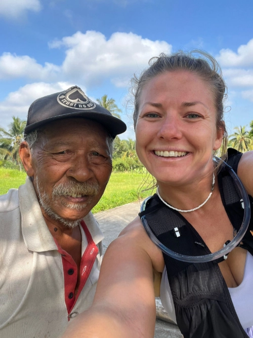 Marie rencontre un habitant local dans les rizières pendant son voyage sportif en Asie.