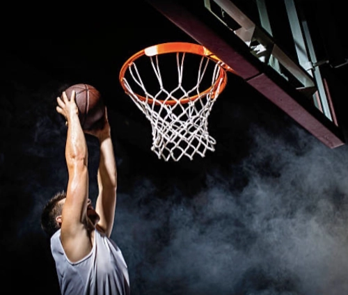 Joueur de basket en plein saut réalisant un dunk, symbole de concentration, d’équilibre intérieur et de performance sportive.
