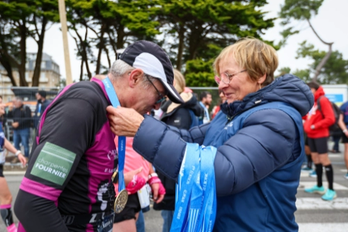 Remise de médaille à un finisher du Marathon de la Côte d’Amour Amarris 2025 à La Baule.