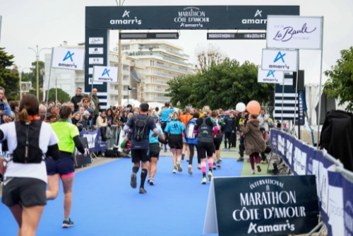 Arrivée du Marathon de la Côte d’Amour Amarris 2025 à La Baule, des coureurs franchissent la ligne finale sous les applaudissements du public.