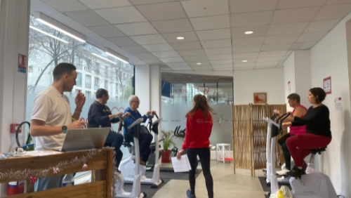 Groupe de personnes utilisant des vélos d’exercices lors d’une séance de sport santé à Saint-Nazaire, encadrées par des intervenants.