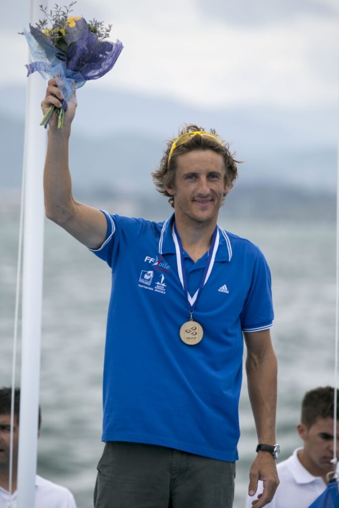 Julien Bontemps, champion du monde RS:X, médaille autour du cou lors de la cérémonie