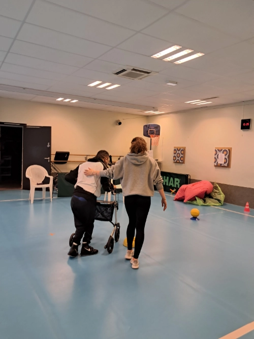 Inès L’HERMITE accompagne Antoine dans un exercice de marche en activité physique adaptée au Centre Saint-Jean-de-Dieu.
