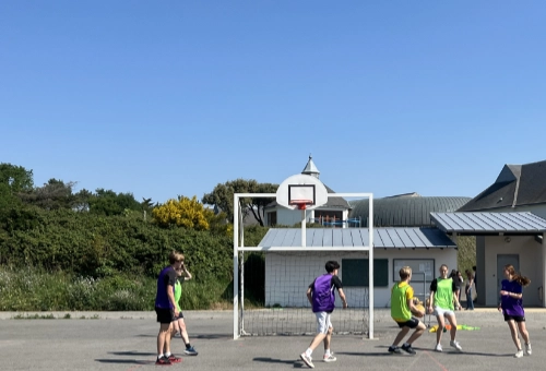 Des élèves jouent au basket sur un terrain extérieur lors d’une séance d’EPS au lycée La Mennais de Guérande.