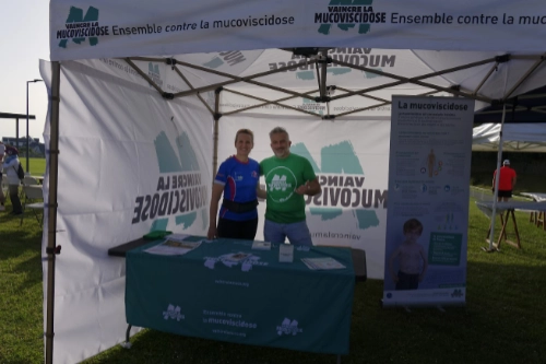Deux personnes accueillent les visiteurs sous un stand Vaincre la Mucoviscidose lors de la Course Nature du Croisic 2026.
