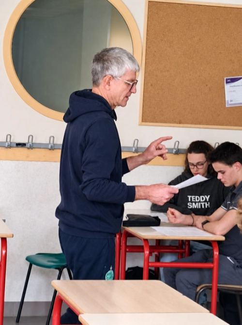 Un enseignant d’EPS donne des consignes à des élèves assis en classe au lycée La Mennais de Guérande.