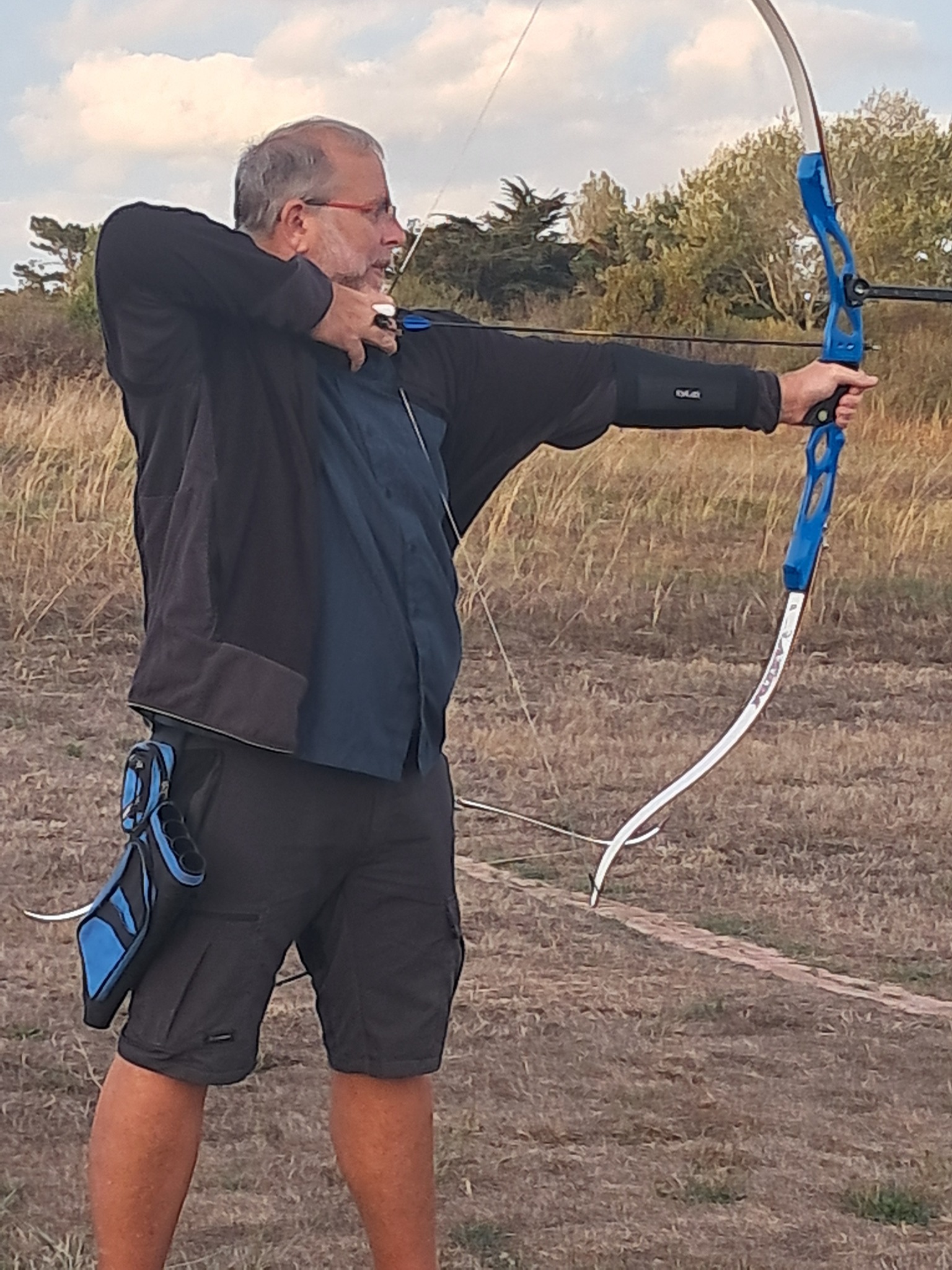 Un archer en pleine visée avec un arc classique sur le terrain du Croisic