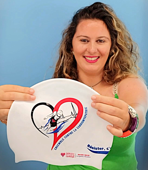 Clémence milite contre la cardiomyopathie hypertrophique avec un message fort Clémence tient un bonnet de bain portant le slogan "Ensemble contre la cardiomyopathie", pour sensibiliser à la cardiomyopathie hypertrophique.